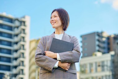 İş kadını güzel bir günde apartmanın önünde duruyor.