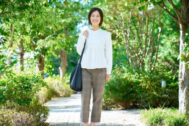 Güzel bir günde yeşil alanda yürüyen bir kadın