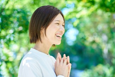 Yeşilliğin ortasında cilt hastalığını kontrol eden bir kadın.