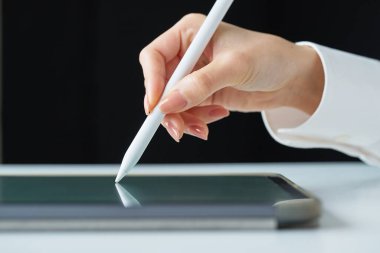 Stüdyoda bir stil kalemi tutuyor.