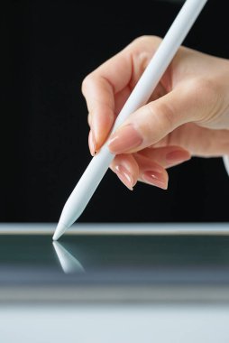 Stüdyoda bir stil kalemi tutuyor.