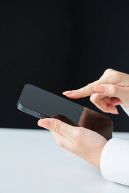 Stüdyoda akıllı telefonun ekranına dokunan eller.