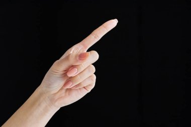 Pointing with index finger at studio of black background clipart