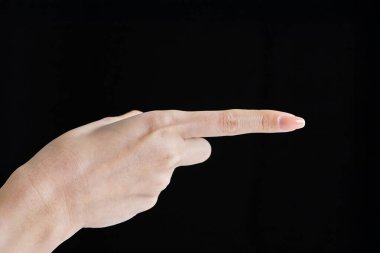 Pointing with index finger at studio of black background clipart