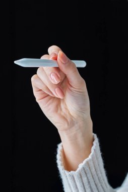 Stüdyoda bir stil kalemi tutuyor.