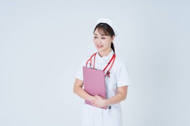 Elinde bir belge tutan ve tıbbi muayeneye giren bir kadın doktor.