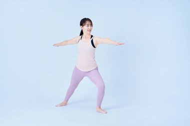 Yoga yapan Asyalı kadın ve beyaz arka plan