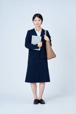 Takım elbiseli genç bir kadın işe gidip geliyor ve beyaz bir geçmişi var.