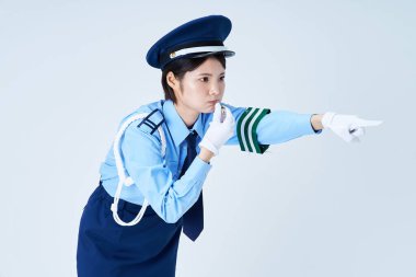 Islık çalan, işaret eden ve beyaz bir geçmişi olan kadın bir güvenlik görevlisi.