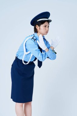 Durmak için poz veren bir kadın güvenlik görevlisi ve beyaz bir arka plan.