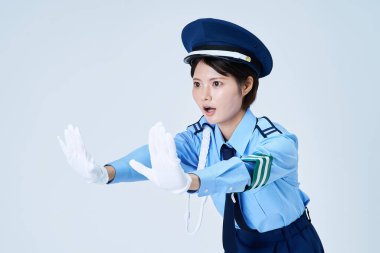 Durmak için poz veren bir kadın güvenlik görevlisi ve beyaz bir arka plan.