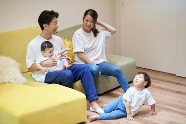 Ebeveynler ve çocuklar bir odada kanepede dinleniyorlar.