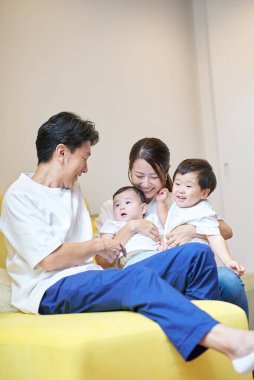 Ebeveynler ve çocuklar bir odada kanepede dinleniyorlar.