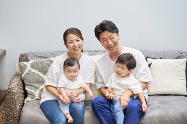 Ebeveynler ve çocuklar bir odada kanepede dinleniyorlar.