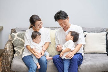 Ebeveynler ve çocuklar bir odada kanepede dinleniyorlar.