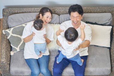 Ebeveynler ve çocuklar bir odada kanepede dinleniyorlar.