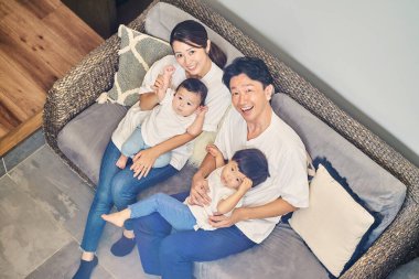 Ebeveynler ve çocuklar bir odada kanepede dinleniyorlar.