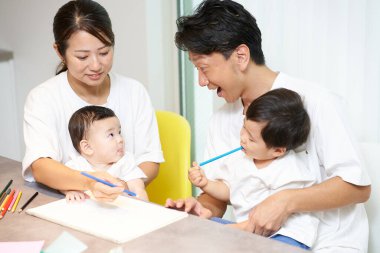 Ebeveynler ve çocuklar evde birlikte oynuyorlar.