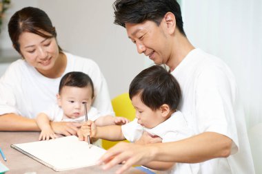 Ebeveynler ve çocuklar evde birlikte oynuyorlar.