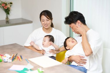 Ebeveynler ve çocuklar evde birlikte oynuyorlar.