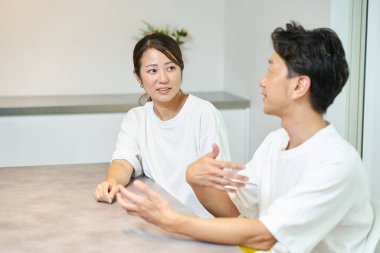 İçerde kibar bir ifadeye sahip bir adama bakan bir kadın.