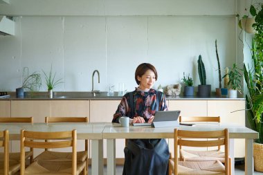 Oturma odasında çalışan orta yaşlı bir kadın.