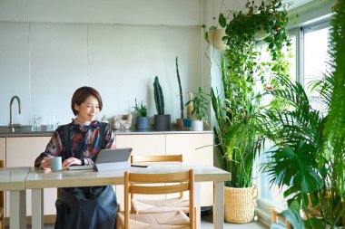 Oturma odasında çalışan orta yaşlı bir kadın.