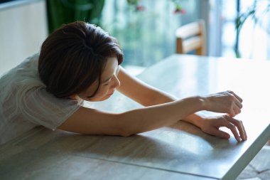 Orta yaşlı bir kadın kendini yorgun hissediyor.