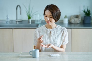 Odasında takviye alan orta yaşlı bir kadın.
