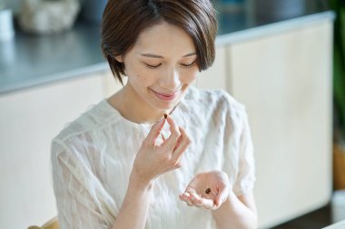 Odasında takviye alan orta yaşlı bir kadın.