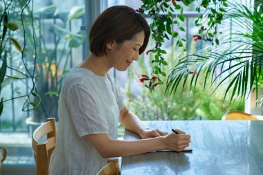 İçeriden not alan orta yaşlı bir kadın.