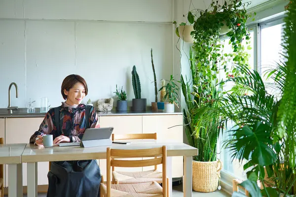 Oturma odasında çalışan orta yaşlı bir kadın.