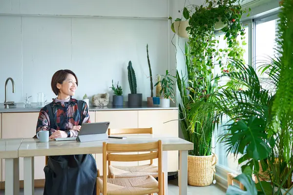 Oturma odasında çalışan orta yaşlı bir kadın.