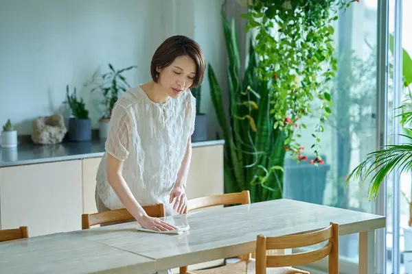 Odayı temizleyen orta yaşlı bir kadın.