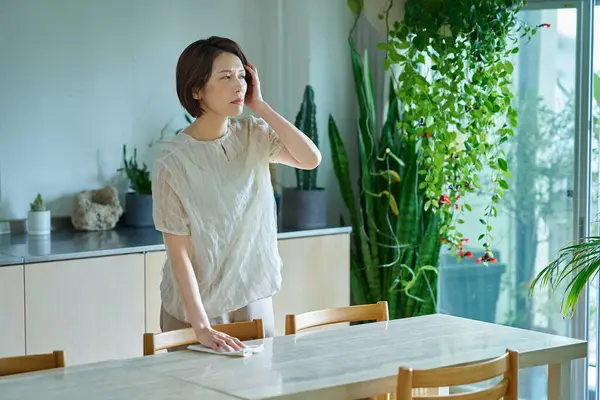 Bir odada baş ağrısı çeken bir kadın.