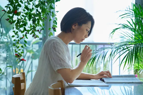 Ders kitabı okuyan orta yaşlı bir kadın.