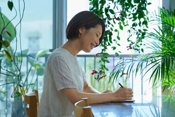 İçeriden not alan orta yaşlı bir kadın.