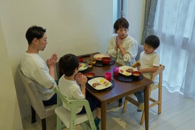 Her gün bir odada yemek yiyen bir ailenin sahnesi.