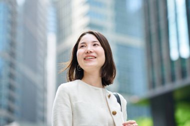 İş bölgesinde işe gidip gelen gülümseyen bir kadın.