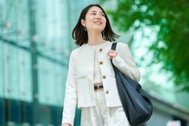 İş bölgesinde işe gidip gelen gülümseyen bir kadın.