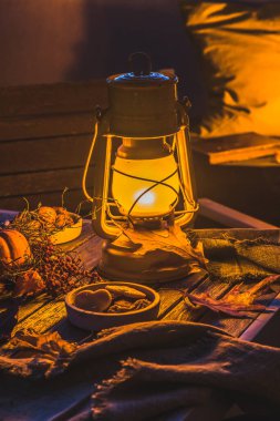 Balkonda rahat bir sonbahar süslemesi. Fenerler, balkabakları, yün battaniyeler ve yapraklarla.