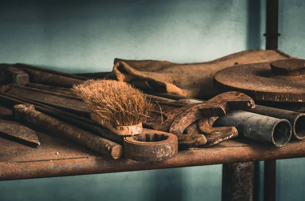 Old rusty tools and a brush on a rusty shelf