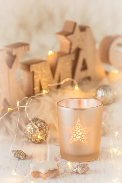 白い木と白い毛皮の上の木製の大文字 クリスマスの装飾 および妖精の光でお茶の光と単語のクリスマスと小さなガラス — ストック写真