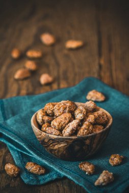 Kırsal ahşap arka planda bir kase tatlı badem, dikey