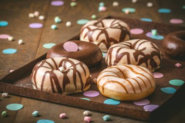 Çikolatalı Donutlar, Berliner, Krapfen... Koyu ahşap arka planda paslı bir tepside.