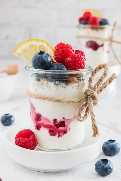 stock image Dessert with yogurt, berries and cereals in a glass on white background, vertical