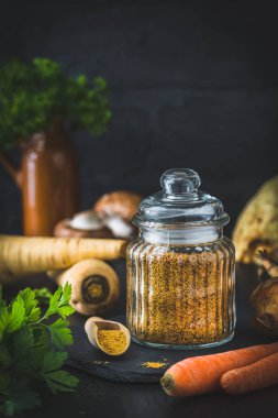 Ev yapımı sebze suyu tozu, organik sebze tozu, siyah arka planda çiğ sebzeler, fotokopi alanı ile dikey.