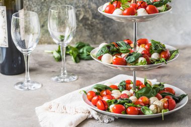 Klasik İtalyan salatası. Kiraz domatesli Insalata Caprese, mini mozarella incileri, fesleğen yaprağı ve balzamik cila.