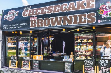 Hockenheim, Deutschland - 18. Mai 2023: Brownie ve cheesecake tatlılarıyla market tezgahı. Uluslararası mutfağı olan yemek kamyonlarıyla sokak festivali, sokak yemekleri pazarı