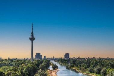 Mannheim, Almanya 'daki Fernmeldeturm ve Neckar nehrine bakın. Televizyon TV telekomünikasyon kulesi. Güzel bir akşam ışığı. Boşluğu kopyala.